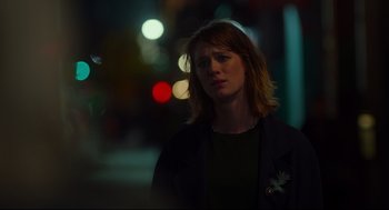 Movie still from “Tully” (2018), directed by Jason Reitman – A woman standing on a street at night with lights in the background; Close Up shot, Over the shoulder angle