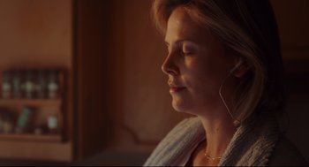Movie still from “Tully” (2018), directed by Jason Reitman – A person wearing headphones with their eyes closed; Close Up shot, High angle