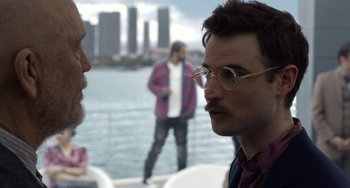 Movie still from “Velvet Buzzsaw” (2019), directed by Dan Gilroy – Two men are talking on a boat in the water; Close Up shot, Over the shoulder angle