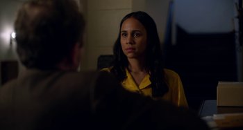 Movie still from “Velvet Buzzsaw” (2019), directed by Dan Gilroy – A woman in a yellow shirt is sitting in front of a man; Close Up shot, Over the shoulder angle