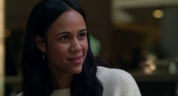 Movie still from “Velvet Buzzsaw” (2019), directed by Dan Gilroy – A person wearing a sweater smiling; Close Up shot, Over the shoulder angle