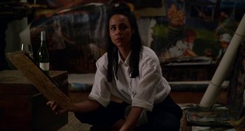 Movie still from “Velvet Buzzsaw” (2019), directed by Dan Gilroy – A woman sitting on the ground holding a piece of paper; Medium shot, High angle