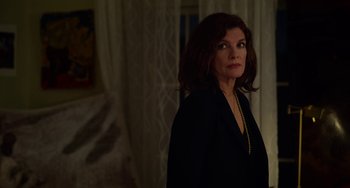 Movie still from “Velvet Buzzsaw” (2019), directed by Dan Gilroy – A woman standing in a dark room looking to her left; Medium shot, Over the shoulder angle