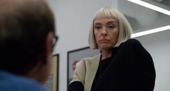 Movie still from “Velvet Buzzsaw” (2019), directed by Dan Gilroy – A woman with blonde hair is looking at a man in a suit; Close Up shot, Over the shoulder angle
