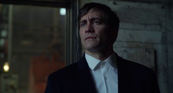Movie still from “Velvet Buzzsaw” (2019), directed by Dan Gilroy – A man wearing a suit and white shirt looking up; Close Up shot, Low angle