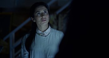 Movie still from “Velvet Buzzsaw” (2019), directed by Dan Gilroy – A woman looking up at the ceiling in a dark room; Close Up shot, Low angle