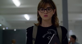 Movie still from “Velvet Buzzsaw” (2019), directed by Dan Gilroy – A woman wearing glasses holding a book in her hands; Close Up shot, Over the shoulder angle