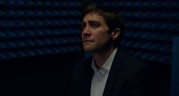 Movie still from “Velvet Buzzsaw” (2019), directed by Dan Gilroy – A person wearing a suit and tie; Close Up shot, Over the shoulder angle