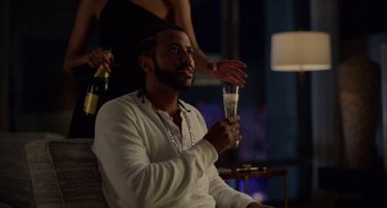 Movie still from “Velvet Buzzsaw” (2019), directed by Dan Gilroy – A man sitting in front of a woman holding a glass of champagne; Medium shot, Over the shoulder angle