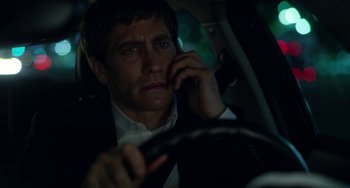 Movie still from “Velvet Buzzsaw” (2019), directed by Dan Gilroy – A man sitting in the back seat of a car while talking on a cell phone; Close Up shot, Over the shoulder angle