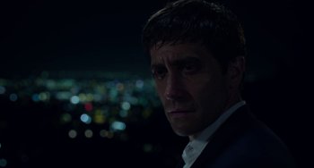 Movie still from “Velvet Buzzsaw” (2019), directed by Dan Gilroy – A person wearing a suit and tie; Close Up shot, Over the shoulder angle