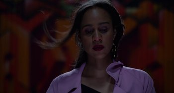 Movie still from “Velvet Buzzsaw” (2019), directed by Dan Gilroy – A woman in a purple jacket is standing in a dark room; Close Up shot, Low angle