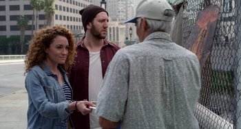 Movie still from “Velvet Buzzsaw” (2019), directed by Dan Gilroy – A group of people standing next to each other on the street; Medium shot, Over the shoulder angle