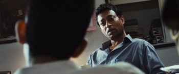 Movie still from “Slumdog Millionaire” (2008), directed by Danny Boyle – A person talking to another person; Close Up shot, Over the shoulder angle