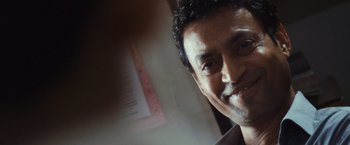 Movie still from “Slumdog Millionaire” (2008), directed by Danny Boyle – A man smiling for the camera; Close Up shot, Low angle