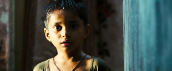 Movie still from “Slumdog Millionaire” (2008), directed by Danny Boyle – A young boy is looking at the camera; Close Up shot, High angle
