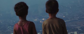 Movie still from “Slumdog Millionaire” (2008), directed by Danny Boyle – Two children looking out at a fire in the distance; Extreme Wide shot, High angle