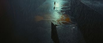 Movie still from “Slumdog Millionaire” (2008), directed by Danny Boyle – A person walking on the beach in the rain at night; Extreme Wide shot, High angle