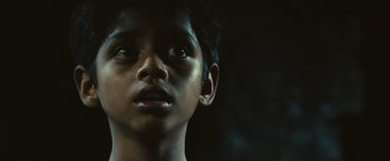 Movie still from “Slumdog Millionaire” (2008), directed by Danny Boyle – A child's face in the dark; Close Up shot, Low angle