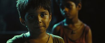 Movie still from “Slumdog Millionaire” (2008), directed by Danny Boyle – A young boy is looking into the camera; Close Up shot, High angle