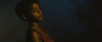 Movie still from “Slumdog Millionaire” (2008), directed by Danny Boyle – A young girl is standing in the dark; Close Up shot, Low angle