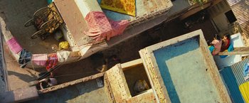 Movie still from “Slumdog Millionaire” (2008), directed by Danny Boyle – An overhead view of a person in a building; Extreme Wide shot, Overhead angle