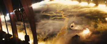 Movie still from “Slumdog Millionaire” (2008), directed by Danny Boyle – An aerial view of a man sitting on a chair in a field; Extreme Wide shot, Overhead angle