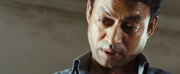 Movie still from “Slumdog Millionaire” (2008), directed by Danny Boyle – A man's face in a shirt and tie; Close Up shot, Low angle