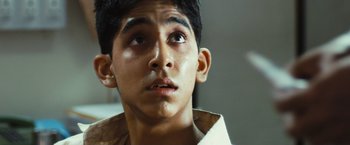 Movie still from “Slumdog Millionaire” (2008), directed by Danny Boyle – A young man's face looking up; Close Up shot, Low angle