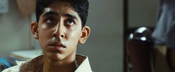 Movie still from “Slumdog Millionaire” (2008), directed by Danny Boyle – A young man looking up into the air; Close Up shot, Low angle