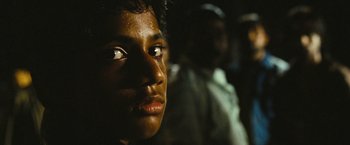 Movie still from “Slumdog Millionaire” (2008), directed by Danny Boyle – A young man's face in the dark; Close Up shot, High angle