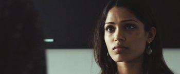 Movie still from “Slumdog Millionaire” (2008), directed by Danny Boyle – A woman's face in a dark room; Close Up shot, Over the shoulder angle