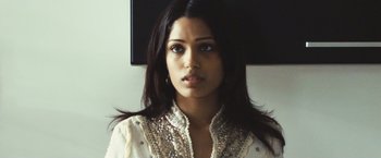 Movie still from “Slumdog Millionaire” (2008), directed by Danny Boyle – A woman with long black hair wearing a white shirt; Close Up shot, Over the shoulder angle