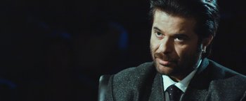 Movie still from “Slumdog Millionaire” (2008), directed by Danny Boyle – A person wearing a suit and tie; Close Up shot, Over the shoulder angle