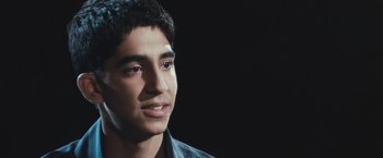 Movie still from “Slumdog Millionaire” (2008), directed by Danny Boyle – A young man is looking into the distance; Close Up shot, Low angle