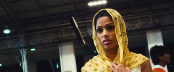 Movie still from “Slumdog Millionaire” (2008), directed by Danny Boyle – A woman in a yellow dress and a yellow head scarf; Close Up shot, Low angle
