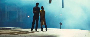 Movie still from “Slumdog Millionaire” (2008), directed by Danny Boyle – A man and a woman standing next to each other on the street; Wide shot, Low angle