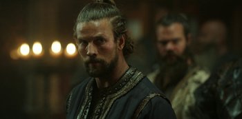 Movie still from “Vikings: Valhalla” (2022), created by Jeb Stuart – A man with long hair and a beard is standing in front of another man with long hair; Close Up shot, Over the shoulder angle