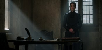 Movie still from “Vikings: Valhalla” (2022), created by Jeb Stuart – A woman standing in front of a table in a dark room; Medium shot, Low angle