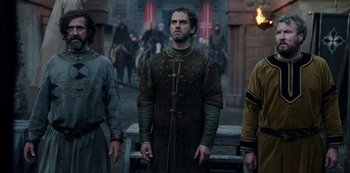 Movie still from “Vikings: Valhalla” (2022), created by Jeb Stuart – A group of men standing next to each other on a street; Medium shot, Low angle
