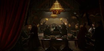 Movie still from “Vikings: Valhalla” (2022), created by Jeb Stuart – A group of people sitting around a table in a room; Extreme Wide shot, High angle