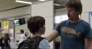 Movie still from “Before Midnight” (2013), directed by Richard Linklater – A young boy and an older man talking to each other; Medium shot, Over the shoulder angle