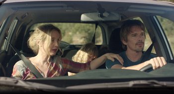 Movie still from “Before Midnight” (2013), directed by Richard Linklater – Two people in the back of a car with a child in the back; Medium shot, Over the shoulder angle