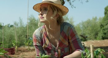 Movie still from “Before Midnight” (2013), directed by Richard Linklater – A woman wearing a straw hat sitting in a field; Close Up shot, Low angle