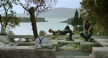 Movie still from “Before Midnight” (2013), directed by Richard Linklater – A man laying on the ground next to a woman; Wide shot, Over the shoulder angle
