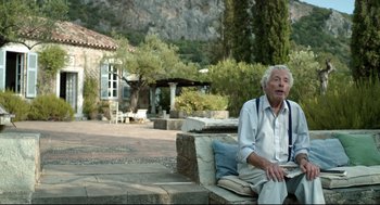 Movie still from “Before Midnight” (2013), directed by Richard Linklater – An older man sitting on a stone bench; Medium shot, Over the shoulder angle