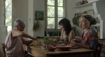 Movie still from “Before Midnight” (2013), directed by Richard Linklater – A group of people sitting around a table eating food; Medium shot, Over the shoulder angle