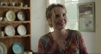 Movie still from “Before Midnight” (2013), directed by Richard Linklater – A woman with blonde hair is smiling for the camera; Close Up shot, Over the shoulder angle