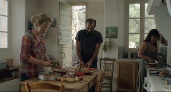 Movie still from “Before Midnight” (2013), directed by Richard Linklater – A man and a woman preparing food on top of a wooden table; Medium shot, Over the shoulder angle