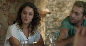 Movie still from “Before Midnight” (2013), directed by Richard Linklater – A woman sitting at a table in front of a man holding a wine glass; Close Up shot, Over the shoulder angle